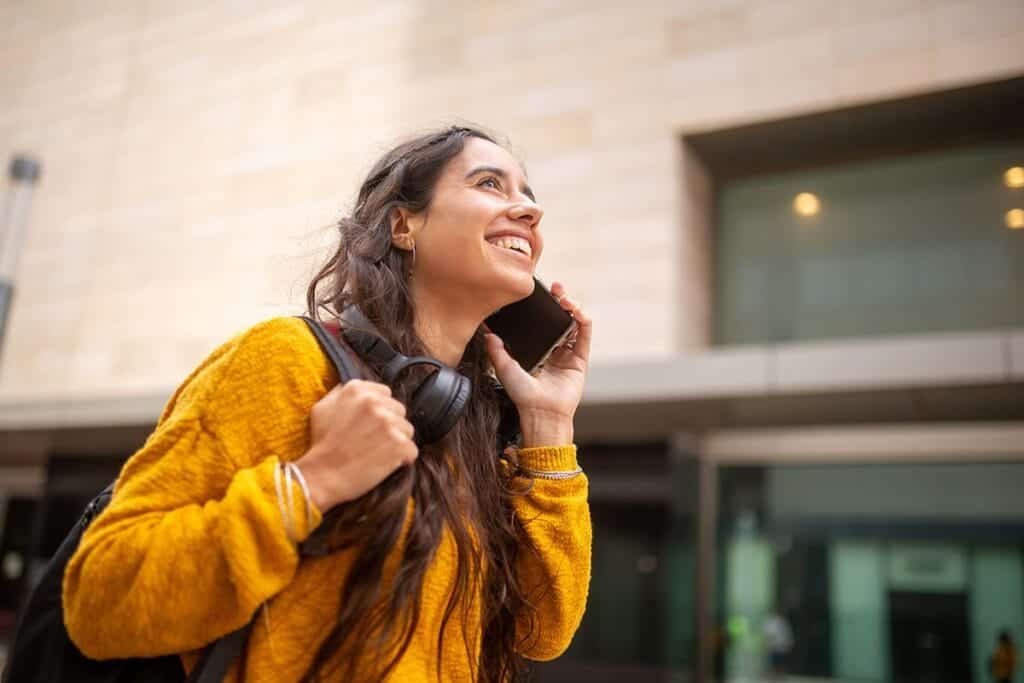 Woman on phone smiles as she discusses her inpatient drug detox experience