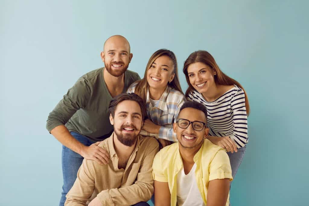 Group of different genders smiles together after attending gender-specific residential treatment